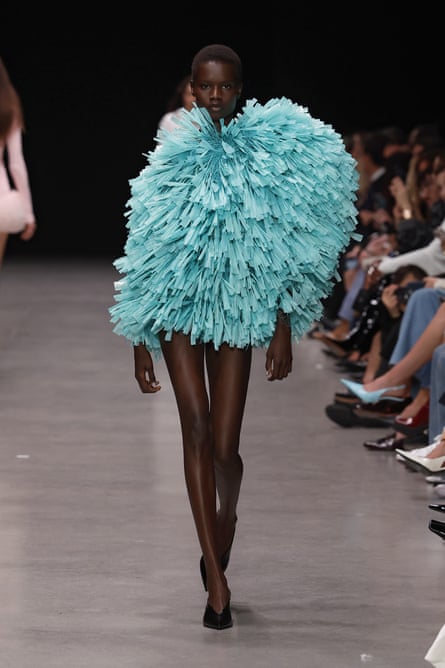 A model in a teal short feathery-looking dress