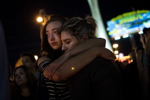 Two women embrace during a candlelit vigil at the junction of Sahara Avenue and Las Vegas Boulevard