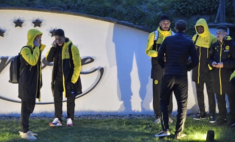 The Dortmund players stand around near to the team bus.