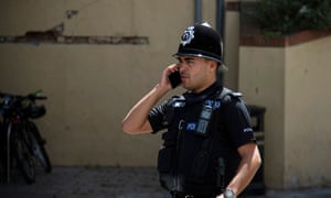 A British police officer talks on the phone without a protective face mask in Gibraltar.