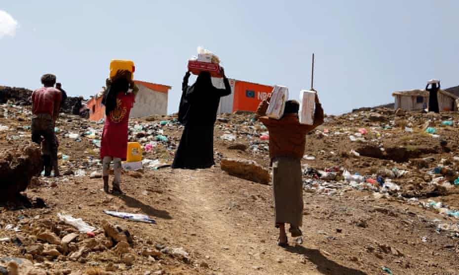 Displaced Yemenis carry food rations provided by a charitable organisation at a camp in Sana’a, Yemen
