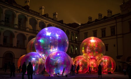 People watch a light installation during the “Festival of Lights” celebrating the 699th anniversary of Vilnius city at the Palace of the Grand Dukes of Lithuania in Vilnius, Lithuania, Tuesday, Jan. 25, 2022. Vilnius Light Festival, that covers the central part of the city, and has gained the recognition of countless visitors, invite guests and residents of the capital of Lithuania to celebrate the birthday of Vilnius city on the 25-29th of January 2022. (AP Photo/Mindaugas Kulbis)