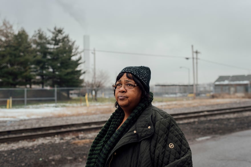 Zulene Mayfield stands on the street she used to live on in Chester, Pennsylvania. Behind her is the Covanta incinerator.