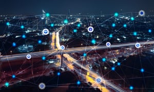 A city at night overlaid with communication icons and network lines