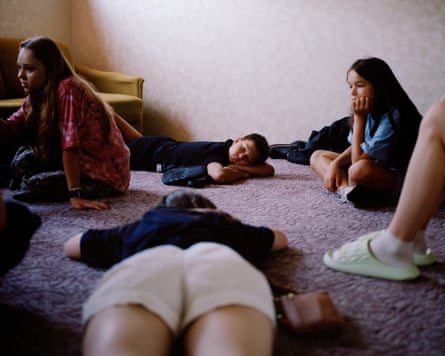 Artem lies down to rest next to some other children