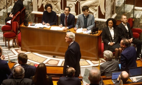 The French prime minister, Michel Barnier, (C) stands before the French National Assembly during debate on parts of France's 2025 budget bill
