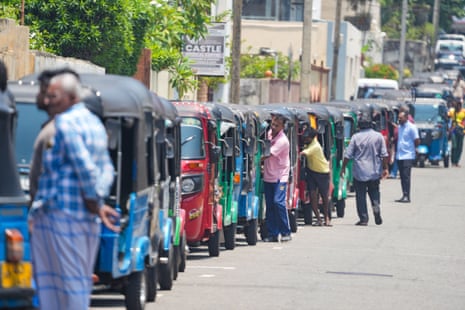 People line up to refuel their vehicles at a petrol station in Colombo, Sri Lanka.