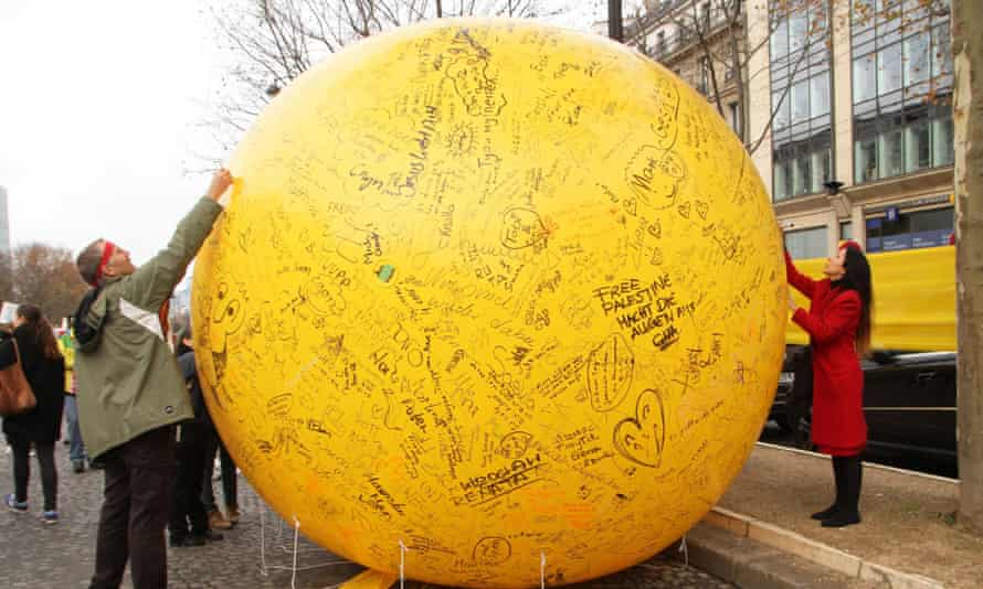 Activists write on a sphere during a demonstration near the Arc de Triomphe.