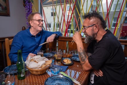 Two men sitting facing each other across a restaurant table