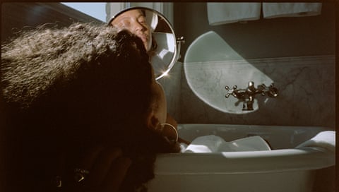 a woman's reflection in a mirror in bathroom