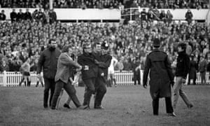 An anti-apartheid demonstrator is escorted from the pitch during East Midlands v South Africa in 1969