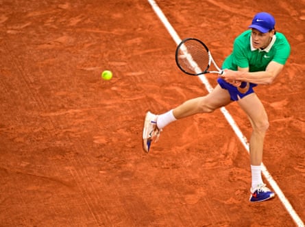 Jannik Sinner plays a backhand return to Novak Djokovic