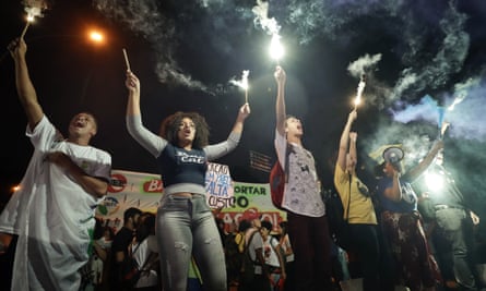 Students light flares as they protest against a massive cut in the education budget imposed by Jair Bolsonaro.