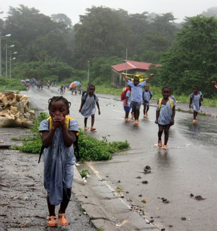 Children are caught in a tropical downpour in Santiago de Baney on Bioko island.