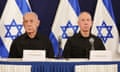 Benjamin Netanyahu and Yoav Gallant sitting with Israeli flags in the background