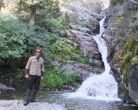 Man standing next to waterfall