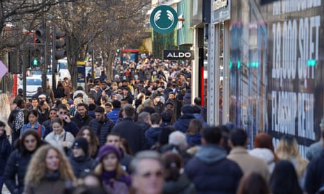 People walk along a busy shopping street, during the traditional Boxing Day sales in London, Britain.