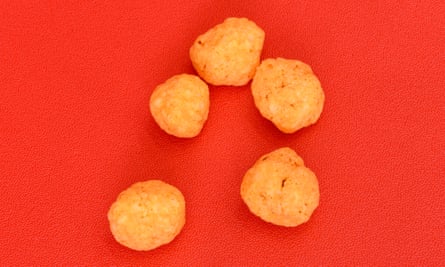 Dried or puffed-up cheddar cheese designed to a savoury snack, on a red background