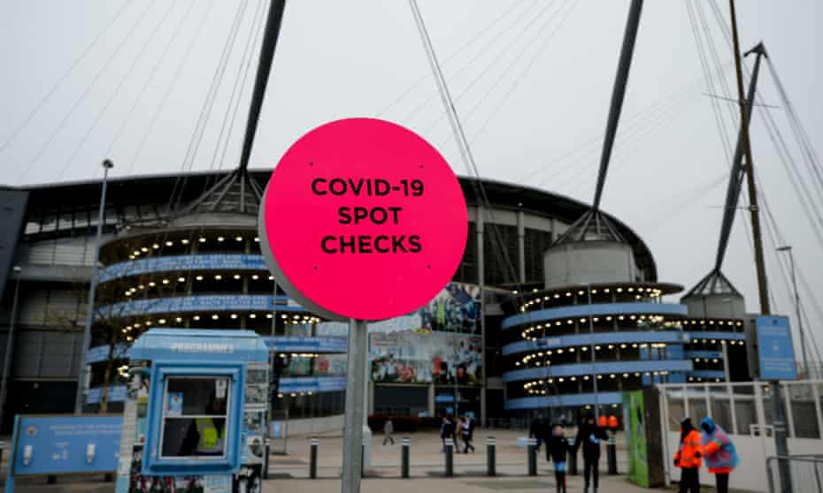 A sign announces coronavirus checks outside the Etihad stadium in Manchester on Sunday.   