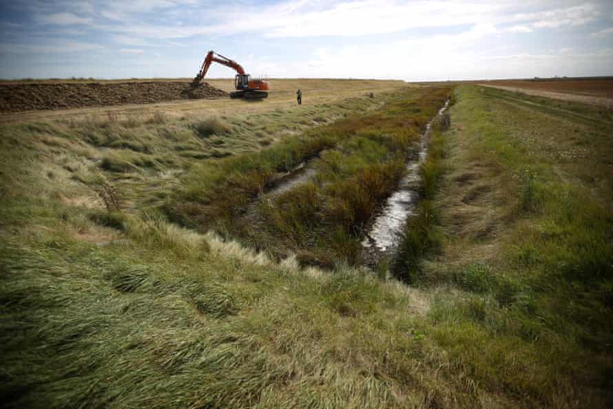 An excavator adjusts a levee off the eastern tip of Wallash Island near Rochford, England, on September 17, 2012.