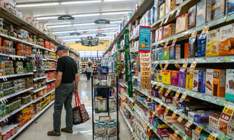 A man looks at canned goods in a grocery store