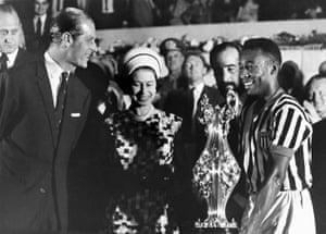 Brazil, 1968: the Queen, with Prince Philip, presents a cup to football player Pele at a stadium in Rio de Janeiro, Brazil, during a state tour of South America