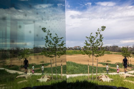 View of the glass front of a building showing faint dots in the glass that distinguish it from the clear landscape.