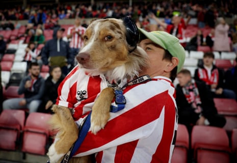 Sunderland fan holds up a dog inside the stadium before the match.