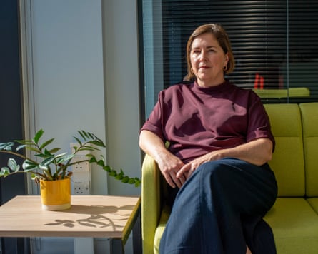 Nicole Jacobs sitting on a green sofa next to a potted plant