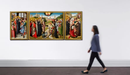 A woman walks towards the tryptich, which is hung on a wall