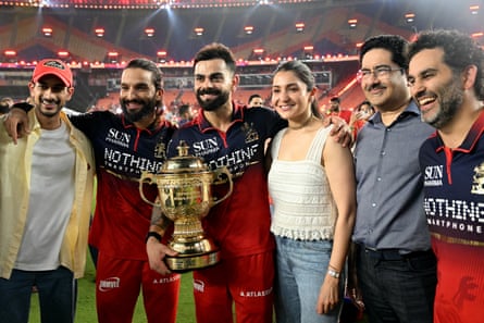 Rajat Patidar (2L) and Virat Kohli (3L) alongside his wife and Bollywood actor Anushka Sharma (3R) and Indian billionaire and Aditya Birla Group chairman Kumar Mangalam Birla (2R) celebrate with the IPL trophy after RCB’s 2026 triumph