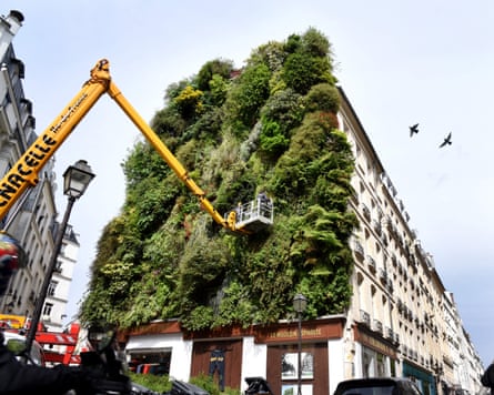 A large green wall with a crane next to it.