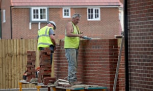 Construction workers build new houses on a housing development in Middlewich, England