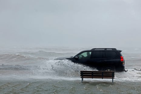 A car drives through a flooded park next to the sea in Galway, Ireland.