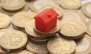 A toy house on a pile of coins