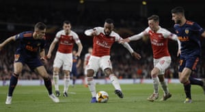 Arsenal’s Alexandre Lacazette, centre, controls the ball between Valencia’s Gabriel, left, his teammate Mesut Ozil and Valencia’s Cristiano Piccini.