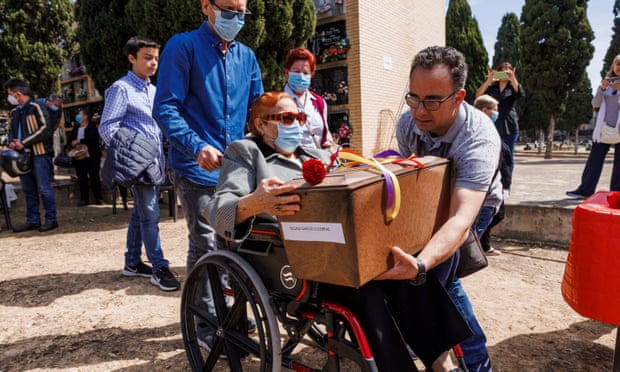 A person in a wheelchair is given a box containing the human remains