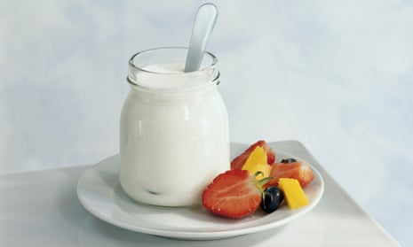 Jar of yoghurt and freshly cut fruit on plate