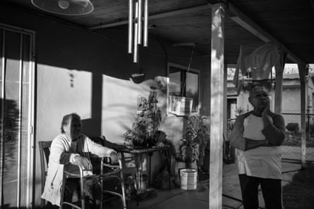 Two women on a patio, one sitting and one standing