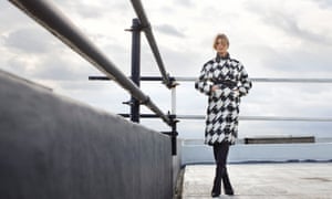 A houndstooth check coat is cinched in at the waist.