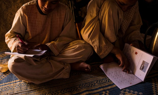 Habib* and Nabi* do their homework in the mud-walled compound the family shares