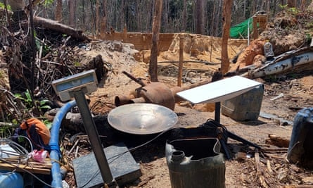 A Starlink terminal placed among various items, with evidence of mining in the background