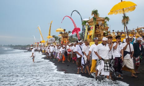 A procession heads down a beach in Bali for a melasti ceremony in the run-up to the Day of Silence.