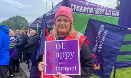 A healthcare representative Emma Creagh with sign saying ‘Not happy with Stormont’