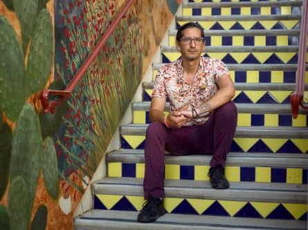 a man sits for a portrait on brightly colored steps on a college campus