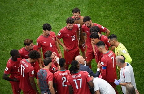 Portugal coach Roberto Martinez speaks to his players during the second half hydration break.