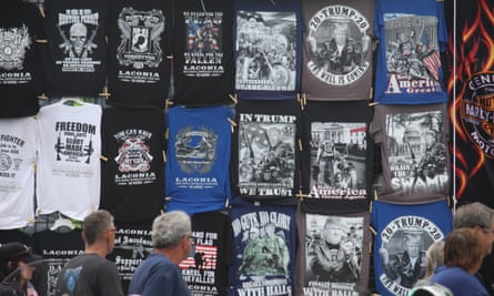 Passersby look at a wall of Trump T-shirts for sale at Laconia, New Hampshire’s bike week.
