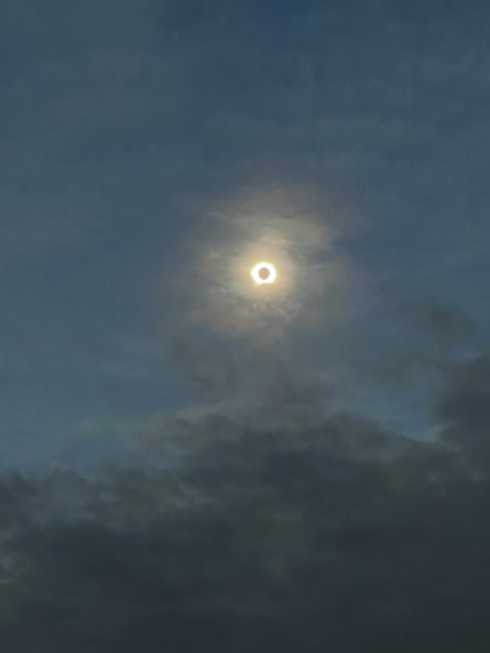 The eclipse visible in a cloudy sky