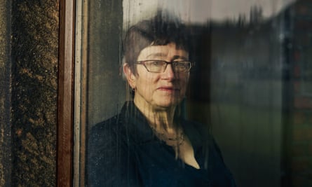 Linda Gask looking out of a rain-streaked window