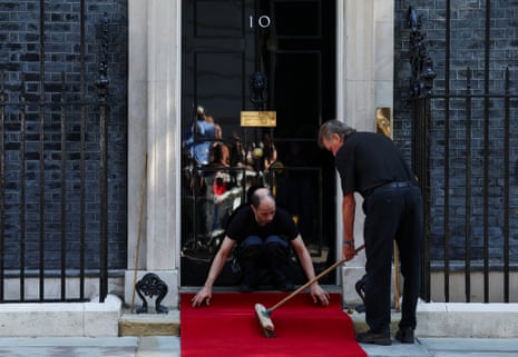 Staff members prepare for the arrival of Emmanuel Macron for the UK-France Summit at 10 Downing Street this morning.